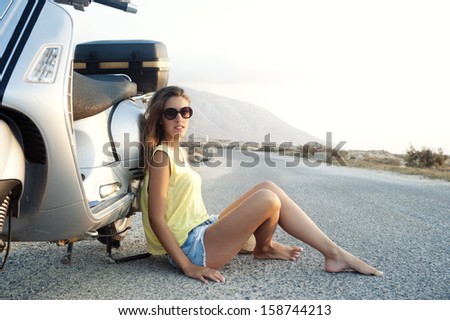 Young female enjoys a motorcycle trip and admires the view