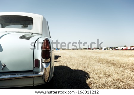 Back view of a classic car parked in a field