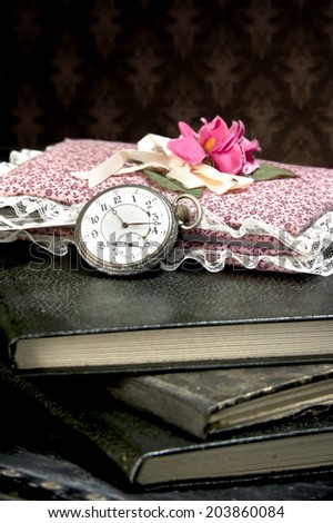 Old watch and books on vintage suitcase