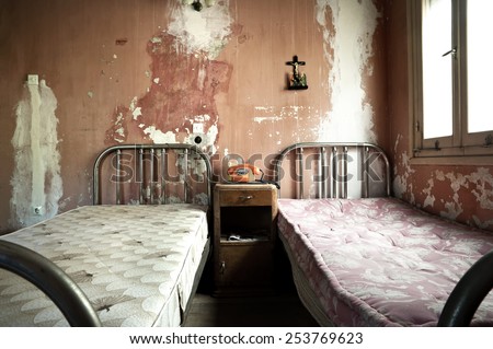 Creepy dirty and abandoned bedroom with cracked walls