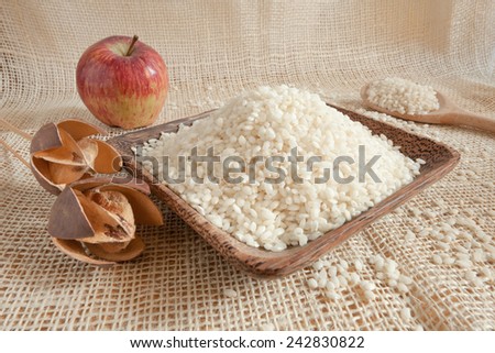white rice as natural ingredient in a wooden cup - country style