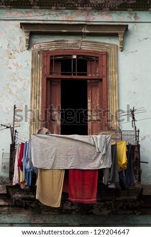 Old ruined balcony with washed clothes drying in the air, Havana. Cuba
