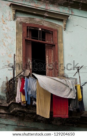 Old ruined balcony with washed clothes drying in the air, Havana. Cuba