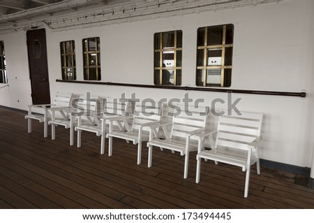 Wooden white chairs on the ship deck