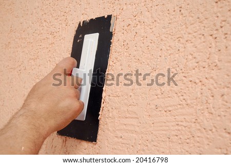 hand holding a plastering tool finishing renovating the wall
