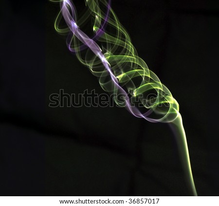 smoke drawing a key music in green and purple colors on dark background