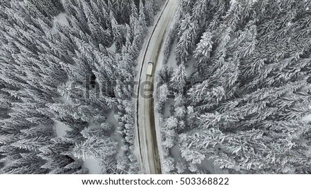 Snowy and frozen winter road with a moving car on it.