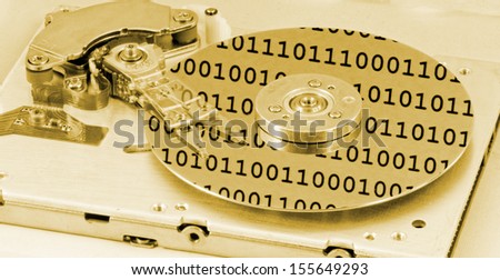 Internals of a computer harddrive with binary number reflections with yellow colors (HDD, winchester)
