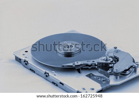 Open computer hard drive on white background with blue