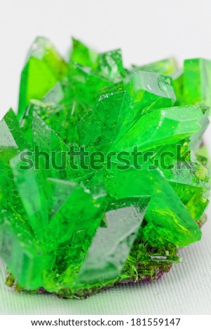 Close up picture about a crystal with emerald color on white background (green crystal)