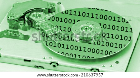 Internals of a computer harddrive with binary number reflections with green colors (HDD, winchester)