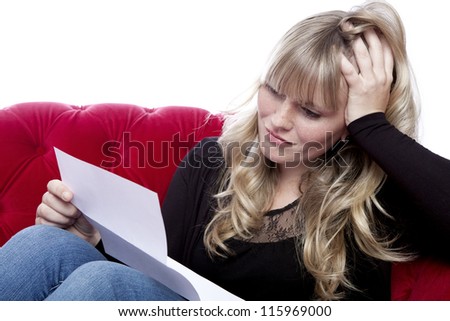 young blond haired girl on red sofa got bad news in front of white background