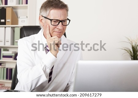 Medical Specialist Seriously Reading Diagnosis Reports at Computer