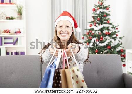 young happy girl is smiling and give somebody presents bags on christmas eve