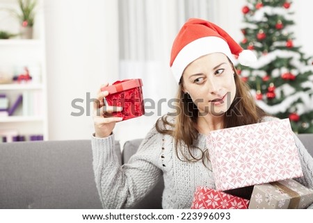 happy young girl is shaking christmas gift and get surprised