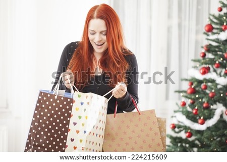 young happy red haired girl with a lot of christmas bags feel good with shopping present gift boxes