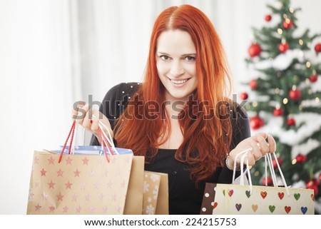 young happy red haired girl with a lot of christmas bags is happy and feel good with shopping present gift boxes