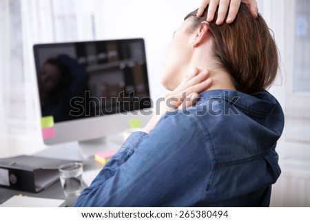 Close up rear View Tired Office Woman Sitting at her Desk Massaging her Neck While Holding her Head.