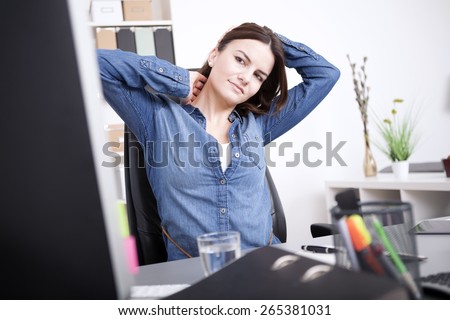 Exhausted Young Office Woman Sitting at her Office, Holding her Head and Neck While Looking at Computer Screen.