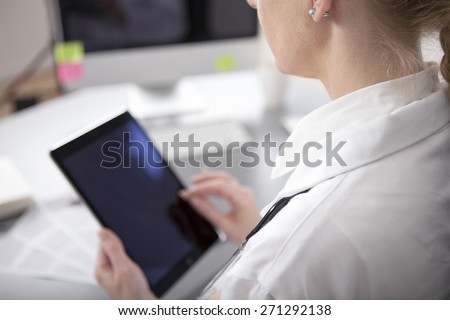 Close up Modern Woman Doctor Holding a Tablet Computer with Blank Screen While at the Office.
