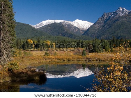 Cabinet Mountains in Fall capped with snow and water reflection