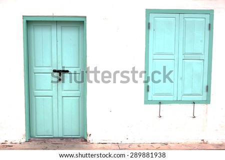 antique green locked door and window colonial style on white wall with mark and dirt