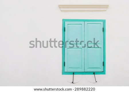 antique green window colonial style on white wall with mark and dirt