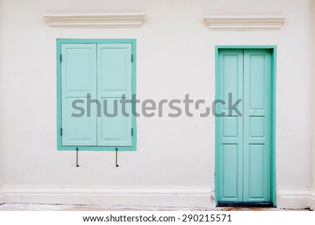 antique green locked door and window colonial style on white wall with mark and dirt