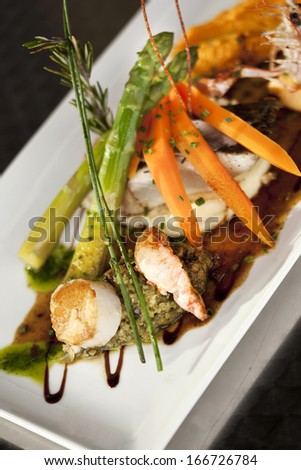 Dish of fish, scampi and Saint-Jacques, with vegetables
