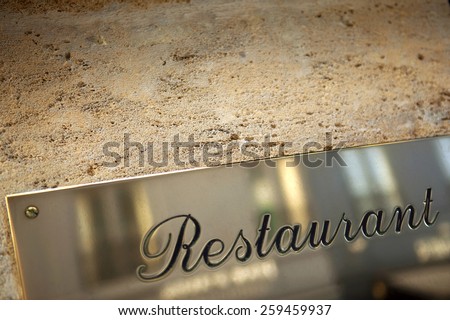 Luxury restaurant signs on a stone wall