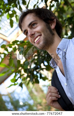Young happy man in a greenhouse