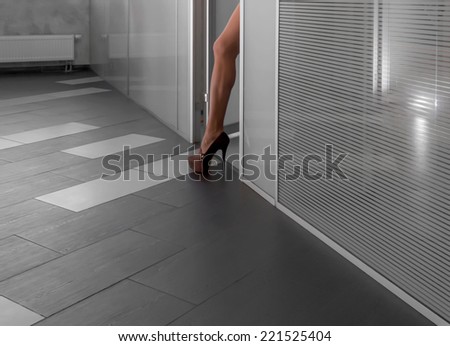 modern office hallway with a business woman stepping out of a room