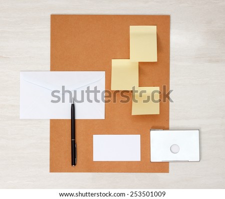 A set of blank envelopes, sticky notes, business card and pen