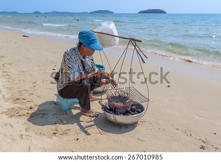 SIHANOUKVILLE, CAMBODIA -  MARCH 05, 2015: unidentified woman seller seafood on a beach
