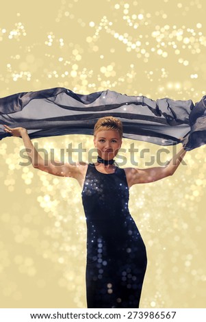 Beautiful young woman in black evening dress holding black fabric at wind with glitter and flare special effect view 1