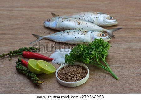 Fresh tuna with fresh pepper, salt and herbs ready for cooking on wooden background, selective focus view 1