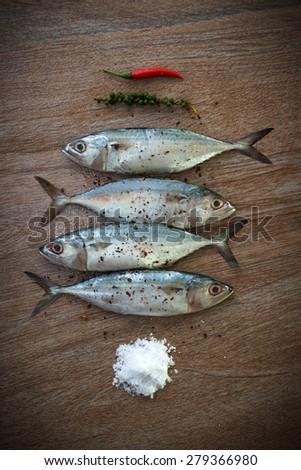 Fresh tuna with grinded and fresh pepper and salt ready for cooking on wooden background