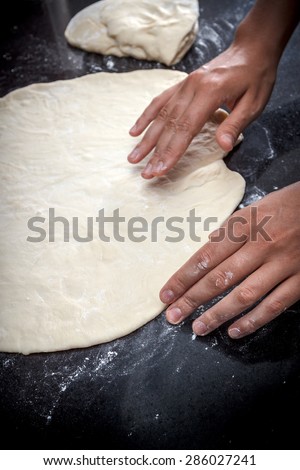 Closeup of a chicken and potato pie cooking process, hands making pastry dough on black marble table, view 3