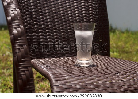 Concept of leisure in the summer time: ralxing in the backyard with a glass of icy water, view 2
