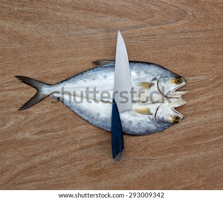 Fresh fish cut on wooden background ready for cooking with a knife, top view