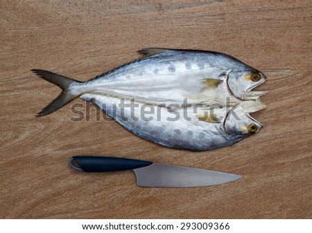Fresh fish cut on wooden background ready for cooking with a knife, top view
