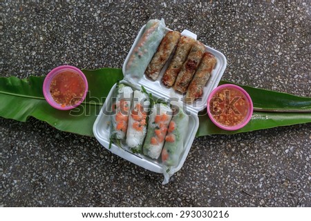 Natural light photo. Vietnamese spring rolls with lettuce, mint, shrimp and vermicelli (Cha gio) fresh and deep fried served with spicy sauce on a stone table outdoors in a tropical park, top view 2