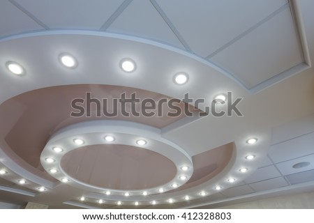 Modern layered ceiling with embedded lights and stretched ceiling inlay, light turned on