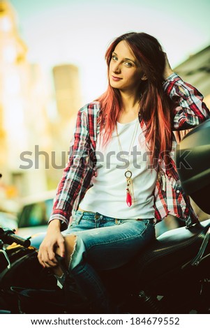 Portrait of young beautiful woman on motorcycle