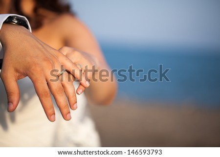 Close up of the hands of a newly married couple showing their wedding rings.