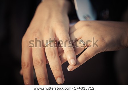 Closeup of the hands of a newly married couple showing their rings.