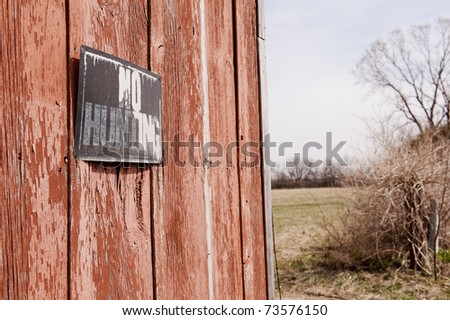No hunting Sign on the side of a decrepit old barn, selective focus on sign