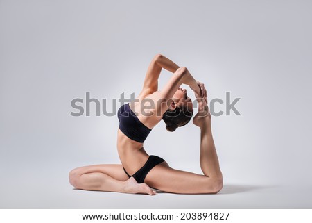 young beautiful yoga posing on a gray studio background young beautiful yoga posing on a gray studio background