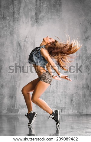 trendy street style dancer jumping on studio background