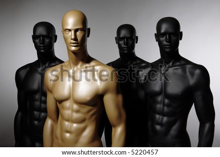 four mannequins standing alone on grey background